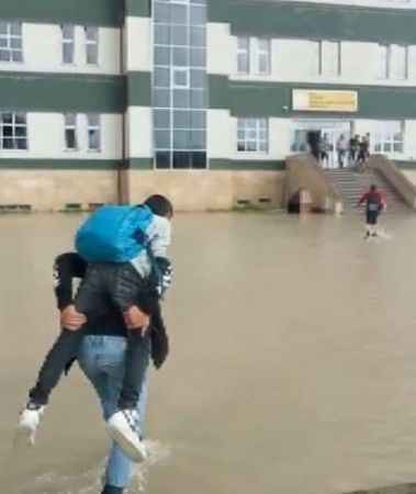 Sivas'ta okul bahçesi sular altında kaldı, öğrenciler birbirini sırtladı